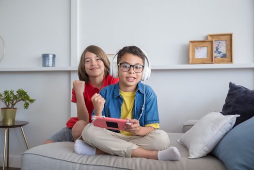 Two children enjoying video games on a colorful console in a cozy living room setting.