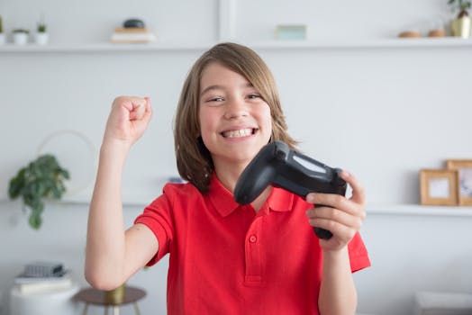 Happy child enjoying a video game session indoors, holding a controller with a winning expression.