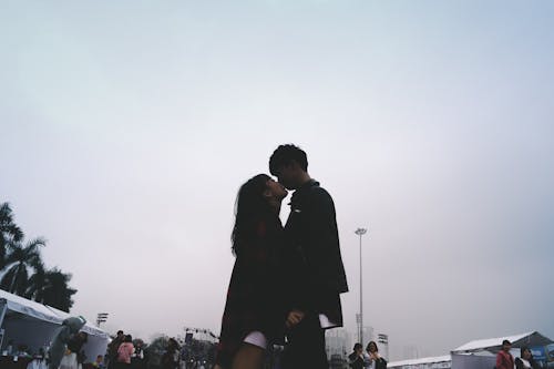 Couple Kissing Together Standing Near People
