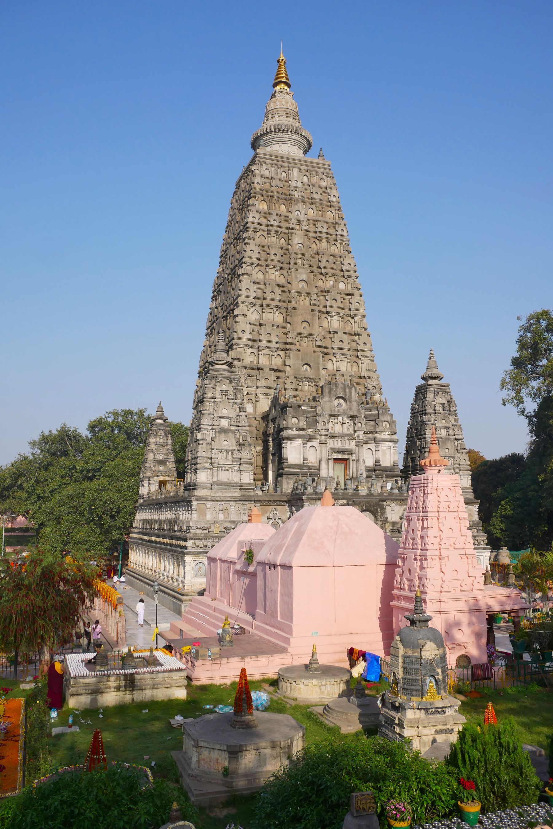 The brick tower of the Mahabodhi Temple above pilgrims in the courtyard