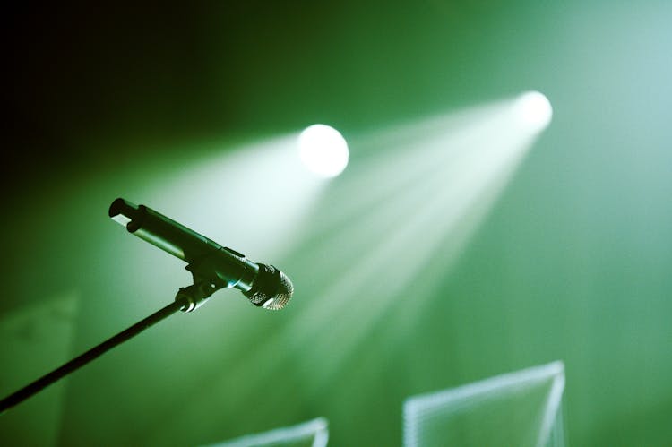 Microphone On Stand Placed On Stage With Green Lights