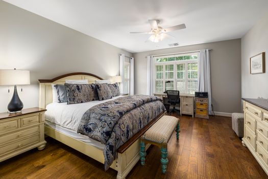 A beautifully designed bedroom with cozy furnishings and abundant natural light.