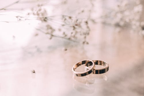 Two Silver-colored Rings on Beige Surface