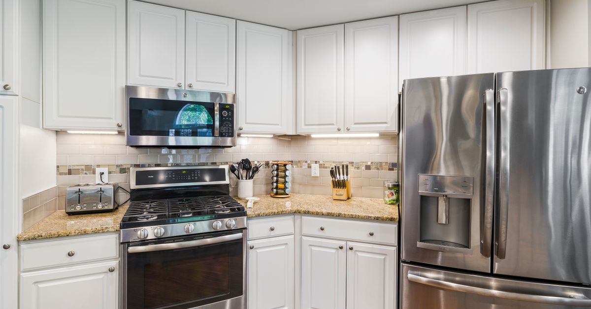 A bright, modern kitchen featuring stainless steel appliances and white cabinetry.