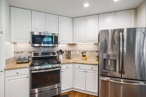 Free A bright, modern kitchen featuring stainless steel appliances and white cabinetry. Stock Photo