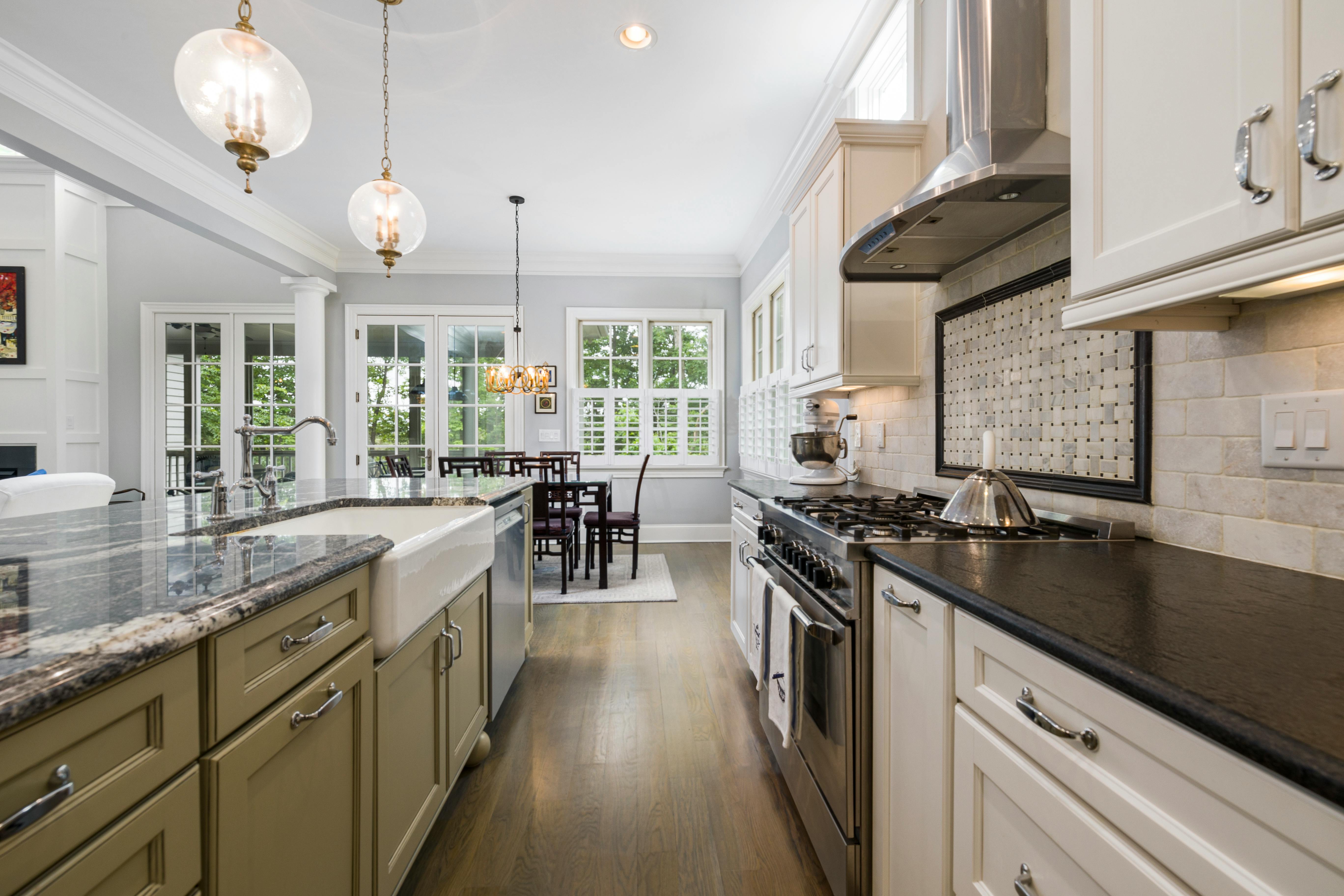 Sleek modern kitchen with high-end appliances and dining area in a bright home.