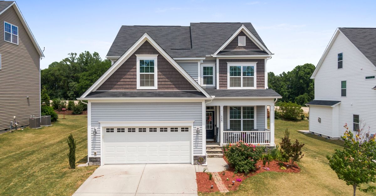 Aerial view of a modern suburban house in Fuquay-Varina with a well-maintained lawn and driveway.
