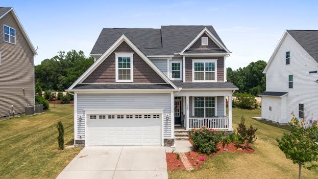 Aerial view of a modern suburban house in Fuquay-Varina with a well-maintained lawn and driveway.