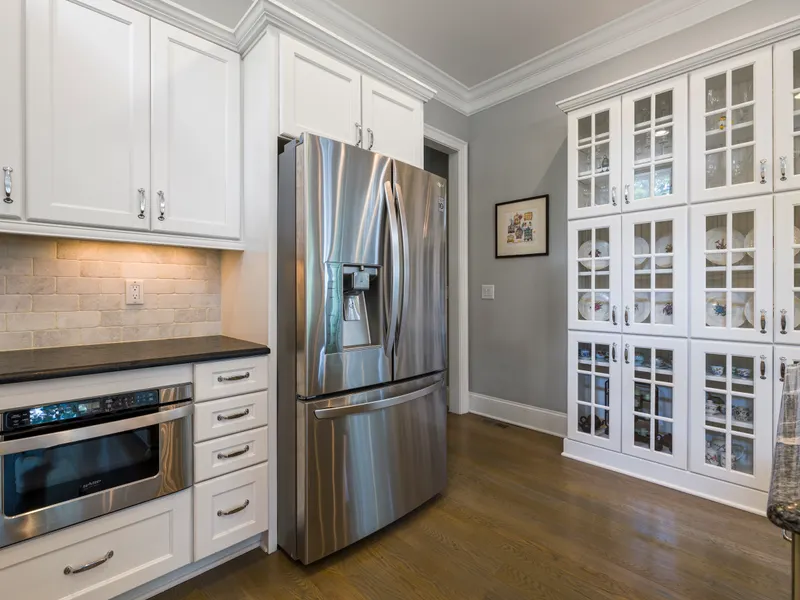 Contemporary kitchen with a stainless steel refrigerator and white cabinets Contemporary kitchen with a stainless steel refrigerator and white cabinets