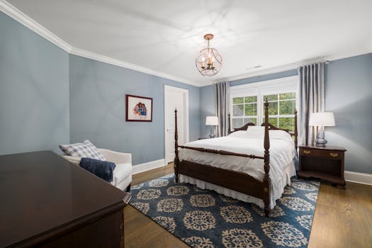 A beautifully decorated bedroom featuring a classic wooden bed, blue walls, and patterned carpet.