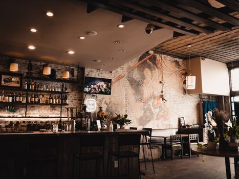 Trendy bar interior showcasing a striking mural and inviting ambiance with warm lighting.