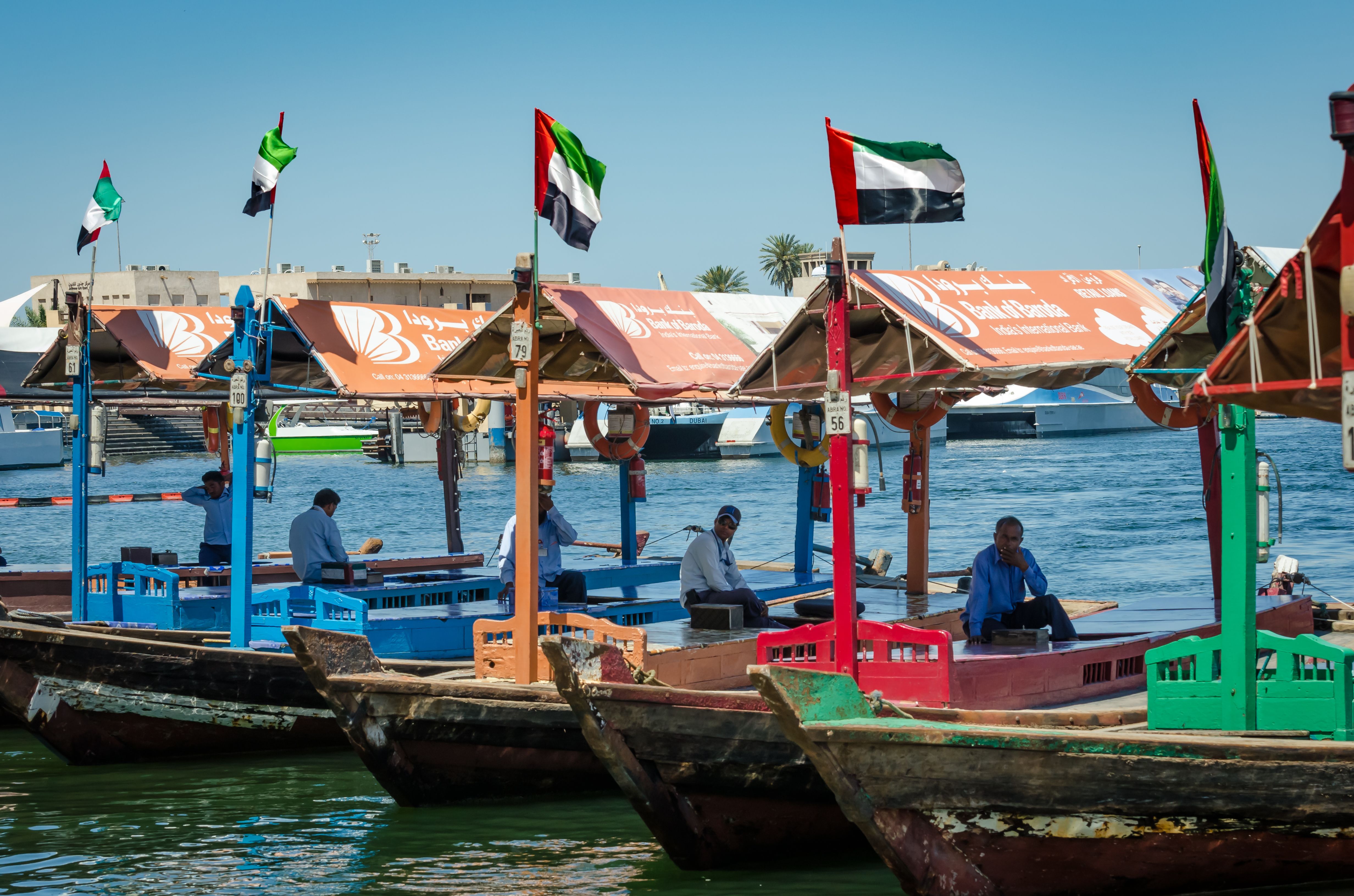 Traditional boats with UAE flags on Dubai Creek waterfront