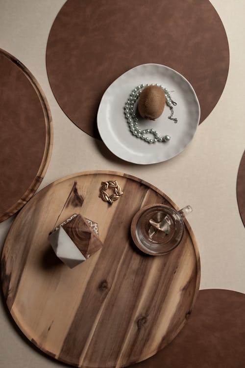 Pearl Necklace and Kiwi on Plate by Wooden Tray