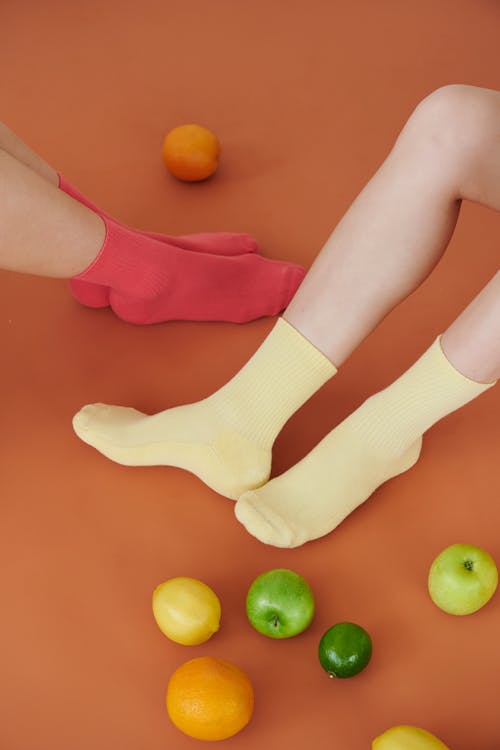 Feet in Bright Socks Among Fresh Fruits