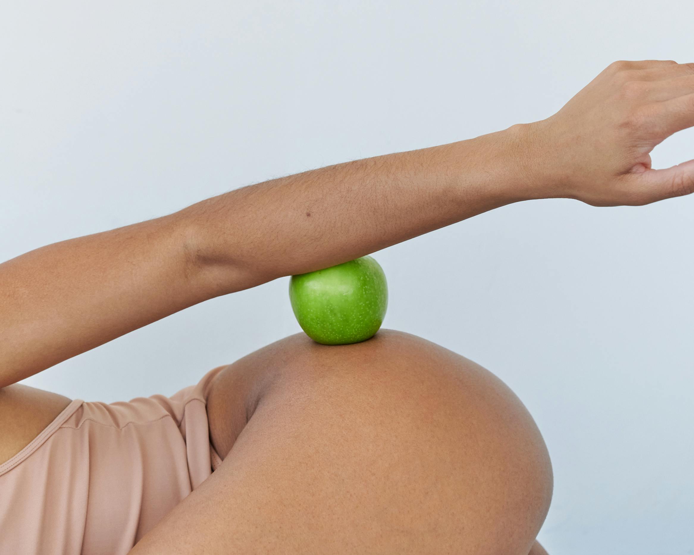 a person holding a green apple