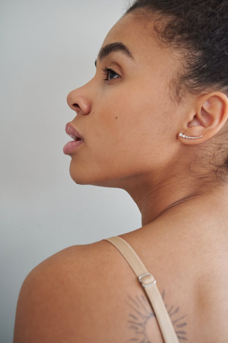 A Woman Looking Up While Wearing A Silver Earring