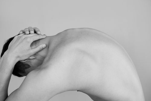 Free Black and white studio shoot capturing a man's shirtless bent posture highlighting the male torso. Stock Photo