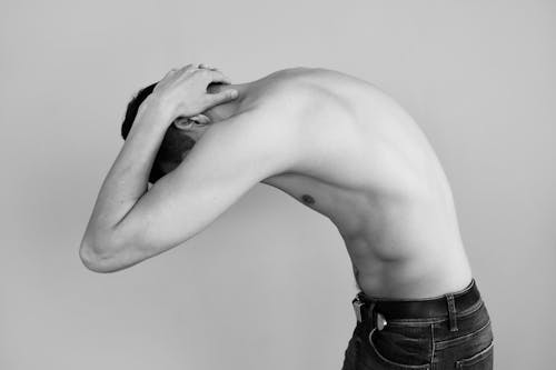 Shirtless Man Bending with his Hands on his Neck