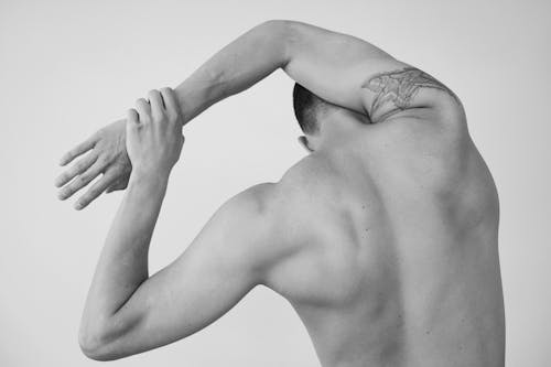 Back View of Stretching Shirtless Man