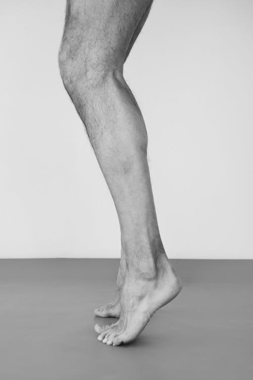 Grayscale Photo of Human's Legs