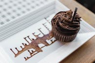 陶瓷盘上特写的巧克力纸杯蛋糕，点缀着艺术巧克力，非常适合甜点爱好者