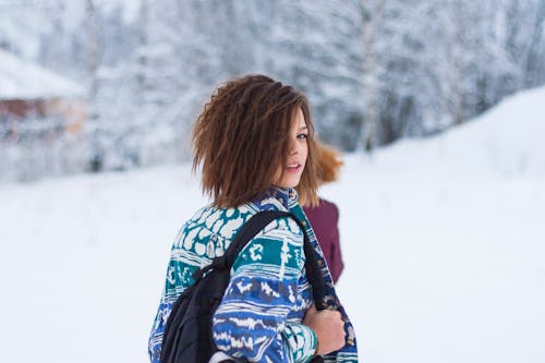 Selektives Fokus Porträtfoto Der Frau, Die Blaue, Grüne Und Weiße Stammesjacke Und Schwarzes Rucksack Outfit Trägt