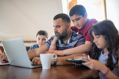 Free Father Surrounded by His Children While Working Stock Photo