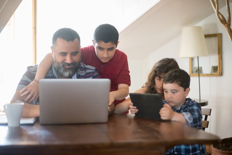 Children Surrounding Their Father At Home