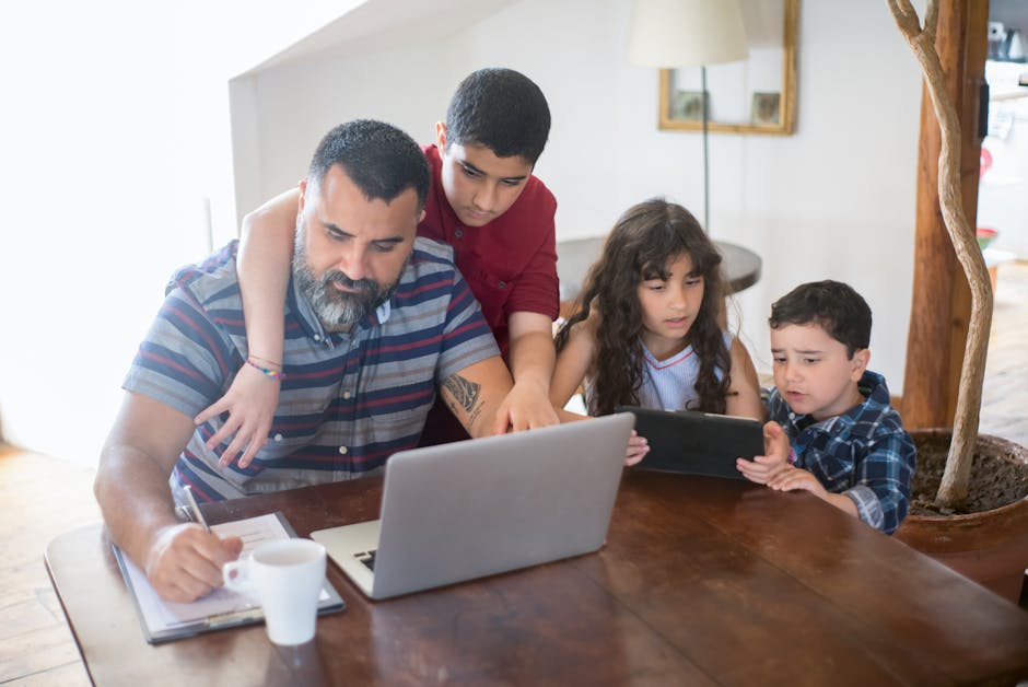 A father and his children engaged in activities with a laptop and tablet at home.