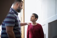 A father and son sharing a moment indoors, highlighting familial connection and bonding.