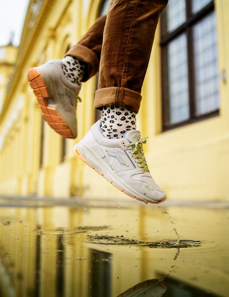 A Person In Sneep Crew Sneakers Jumping In A Puddle