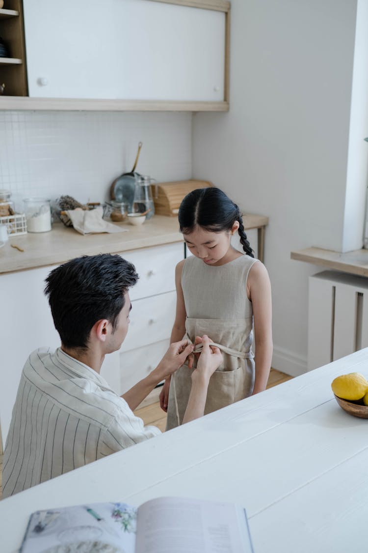 Man And Child Tying An Apron