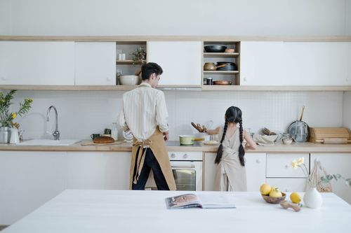 Free A father and daughter preparing food in a modern kitchen setting. Stock Photo