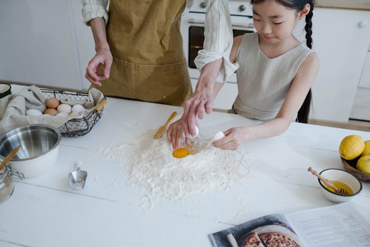 Young Girl Cracking An Egg