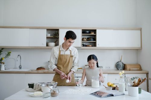 Free Father and daughter enjoy quality time baking together in a stylish kitchen environment. Stock Photo