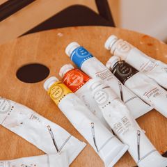 Tubes of paint in different colours on a wooden palette