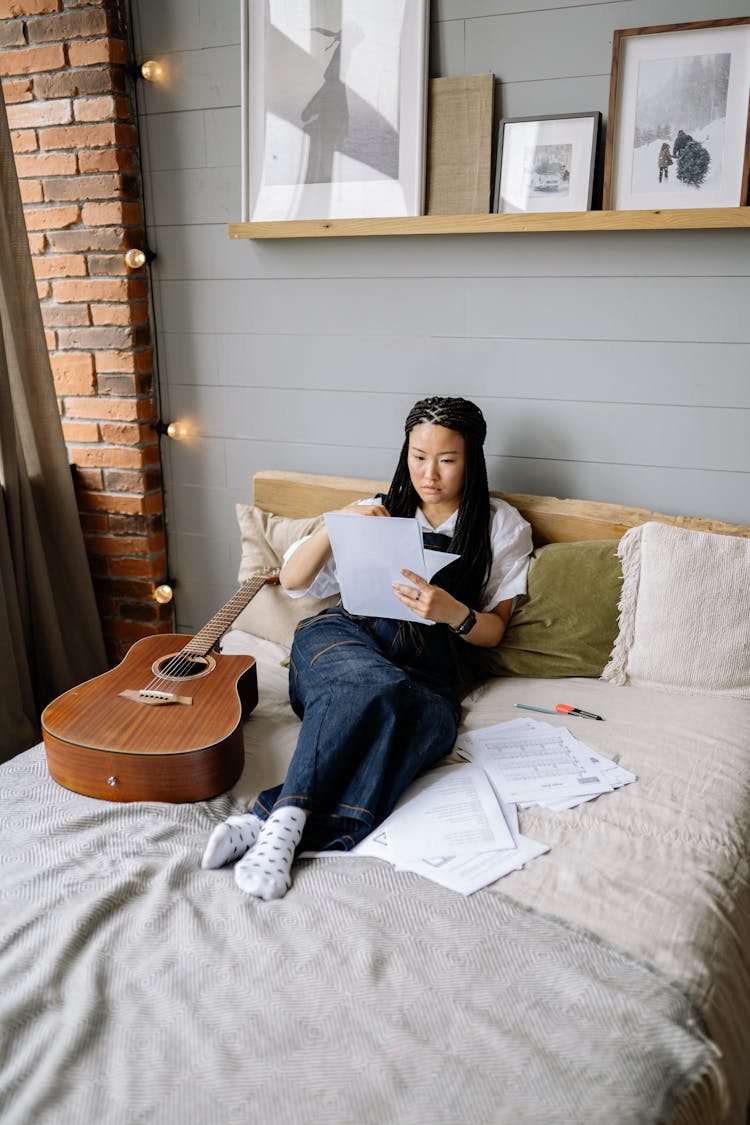 Woman With Music Sheets On Bed