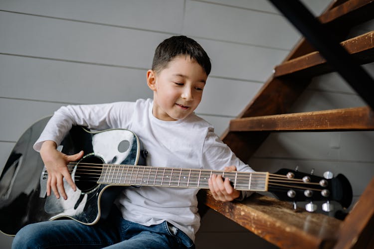 A Boy Playing A Guitar