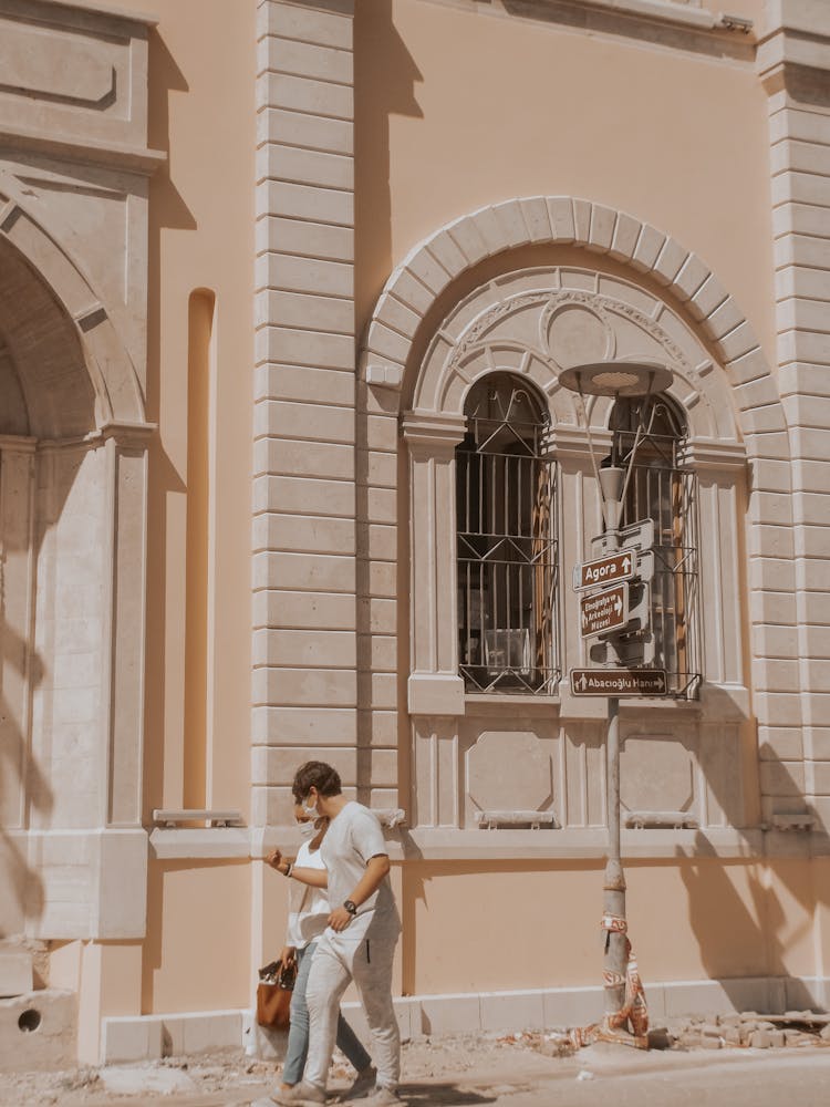 Couple Walking Near Old Building In Historic District