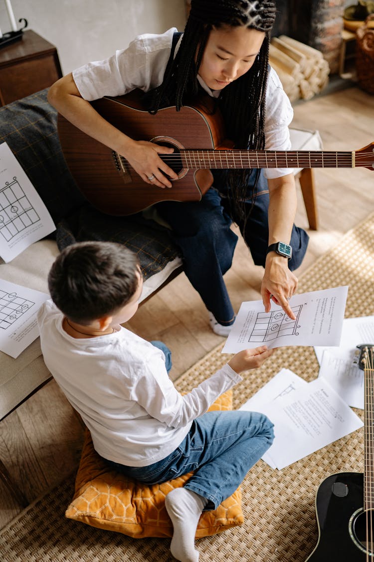 Woman With Braided Hair Pointing At A Music Sheet