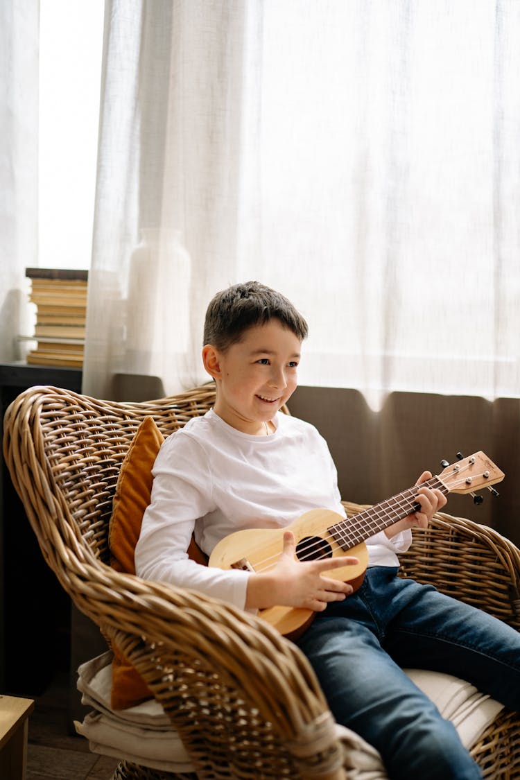 A Kid Playing The Ukulele