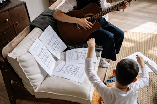 Free Woman Teaching a Child to Play a Guitar Stock Photo
