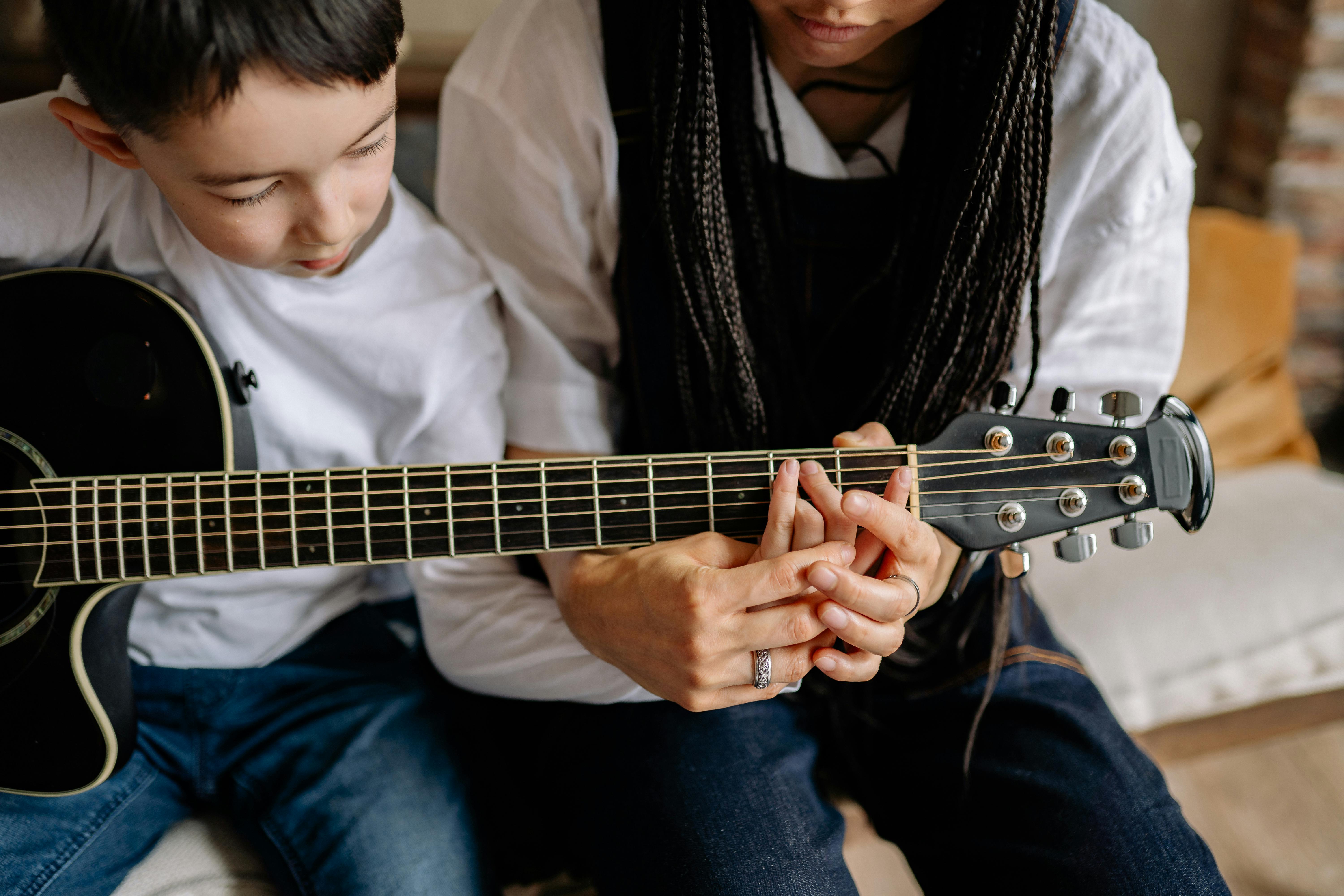 A Man Sitting while Playing Guitar · Free Stock Photo