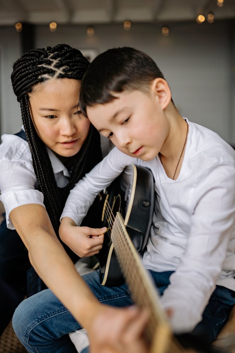 Young Boy Playing A Guitar