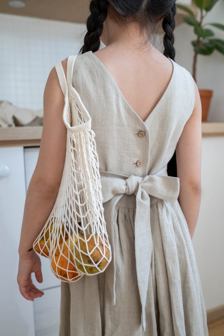 Girl Carrying A Bag Of Fruits