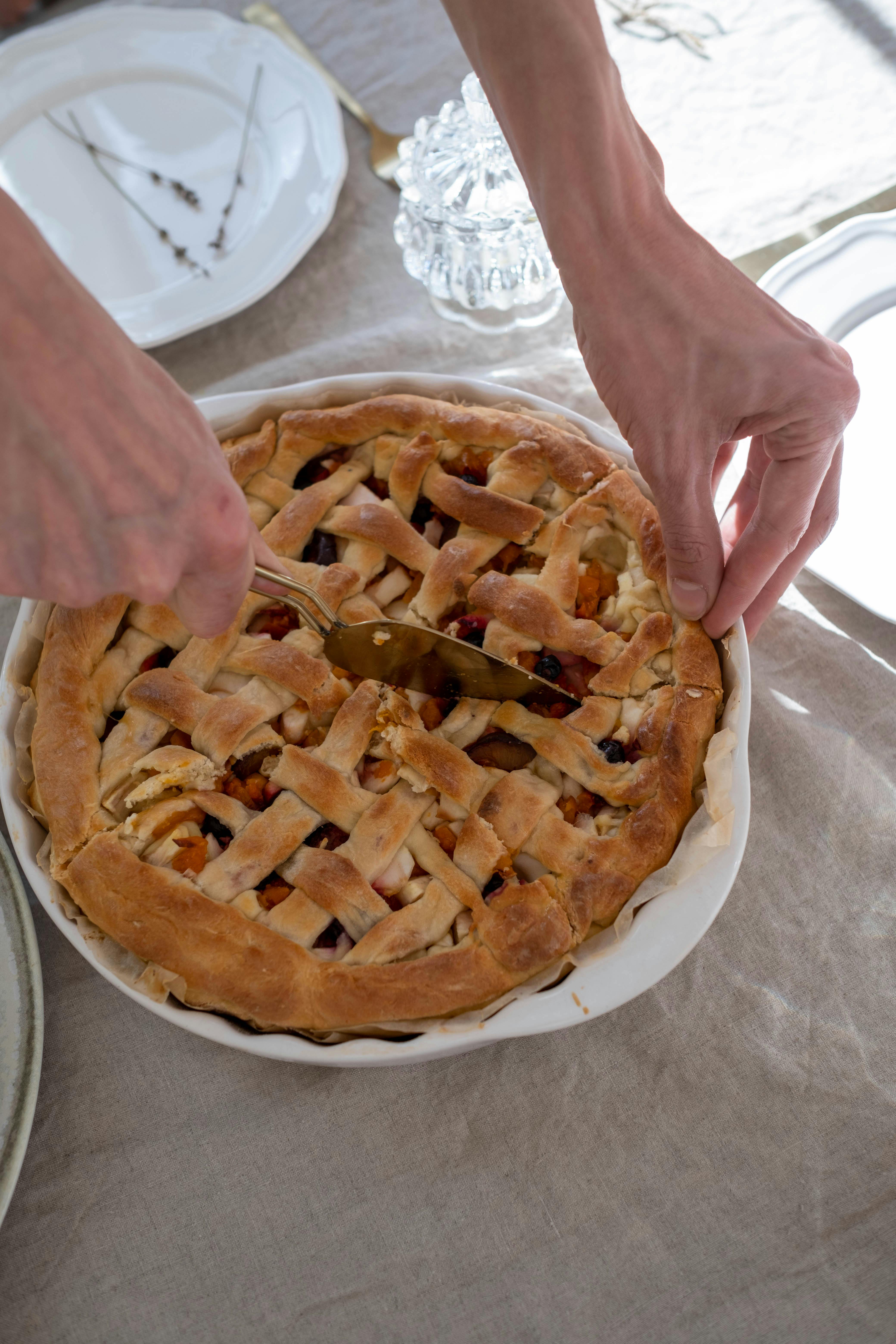 close up shot of a person slicing an apple pie