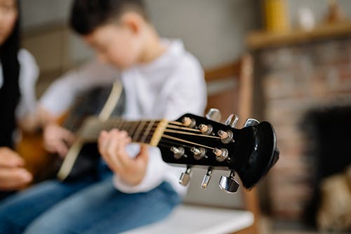 Man in White Shirt Playing Guitar