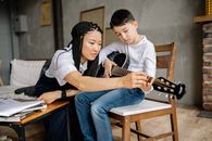 Teacher Teaching a Boy To Play a Stringed Instrument