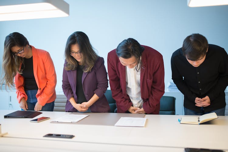 A Group Of People Bowing