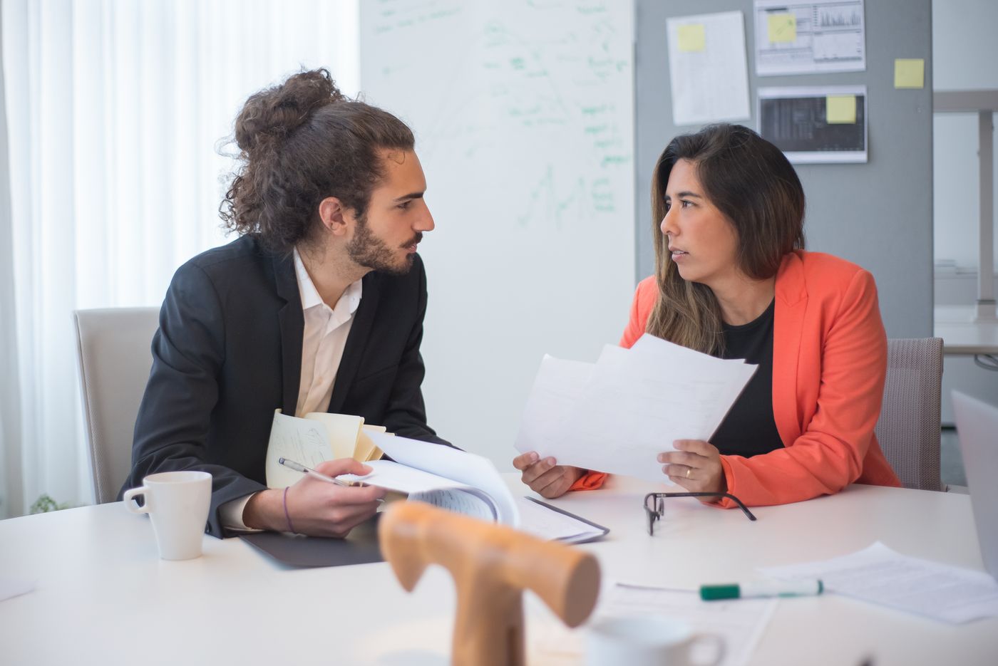 Two colleagues discussing at a desk